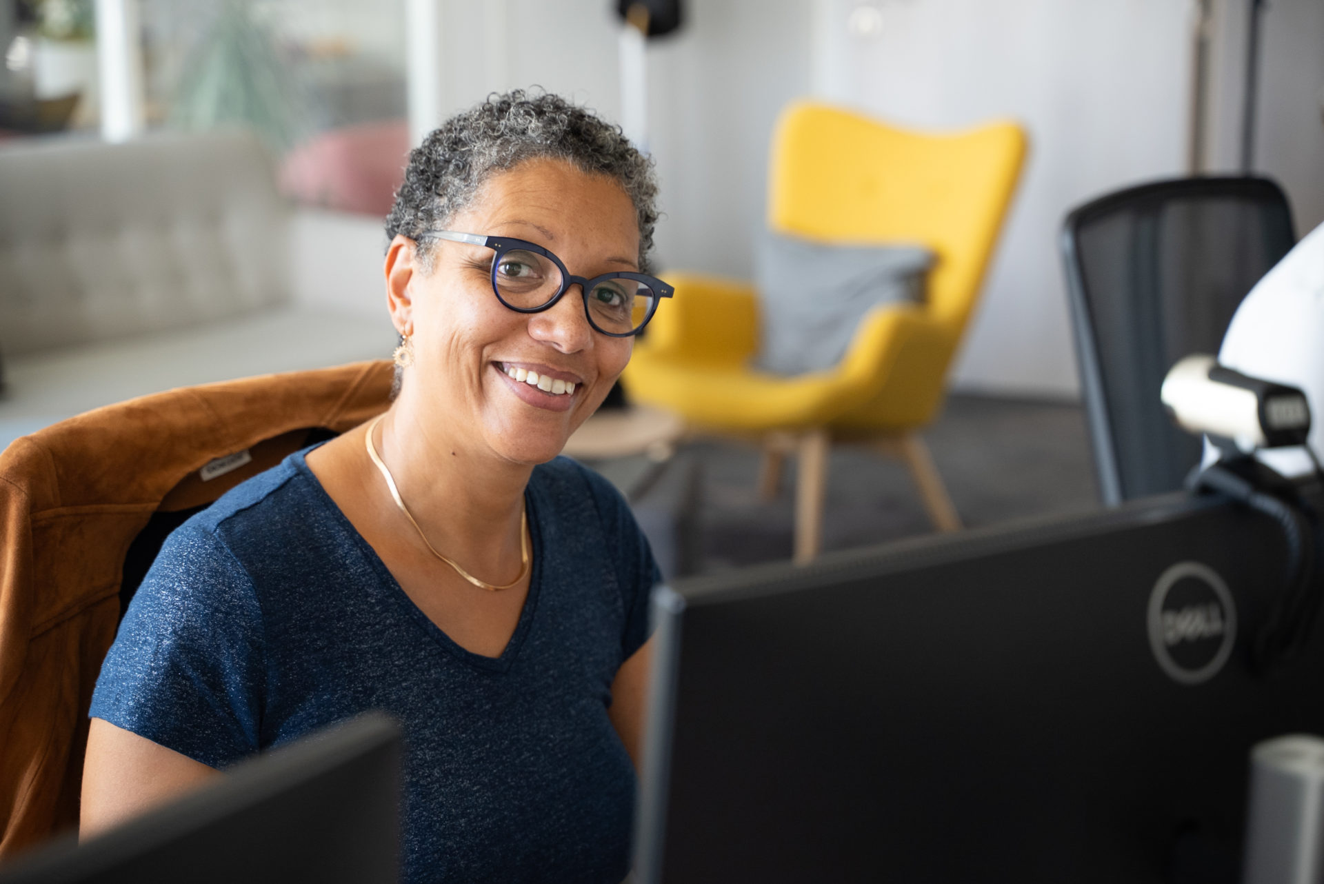 Portrait d'une collaboratrice souriante assise dans les bureaux de l'agence Winbound