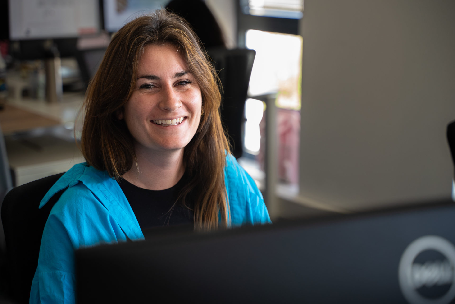 Portrait d'une collaboratrice assise dans les bureaux de l'agence Winbound