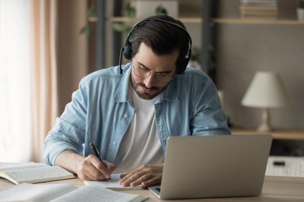 homme écoutant un podcast sur l'ABM marketing et prenant des notes