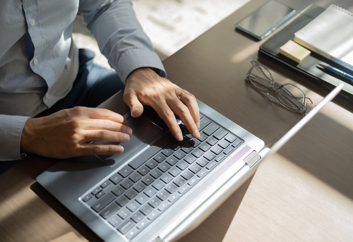 une personne écrit un mail sur son ordinateur portable