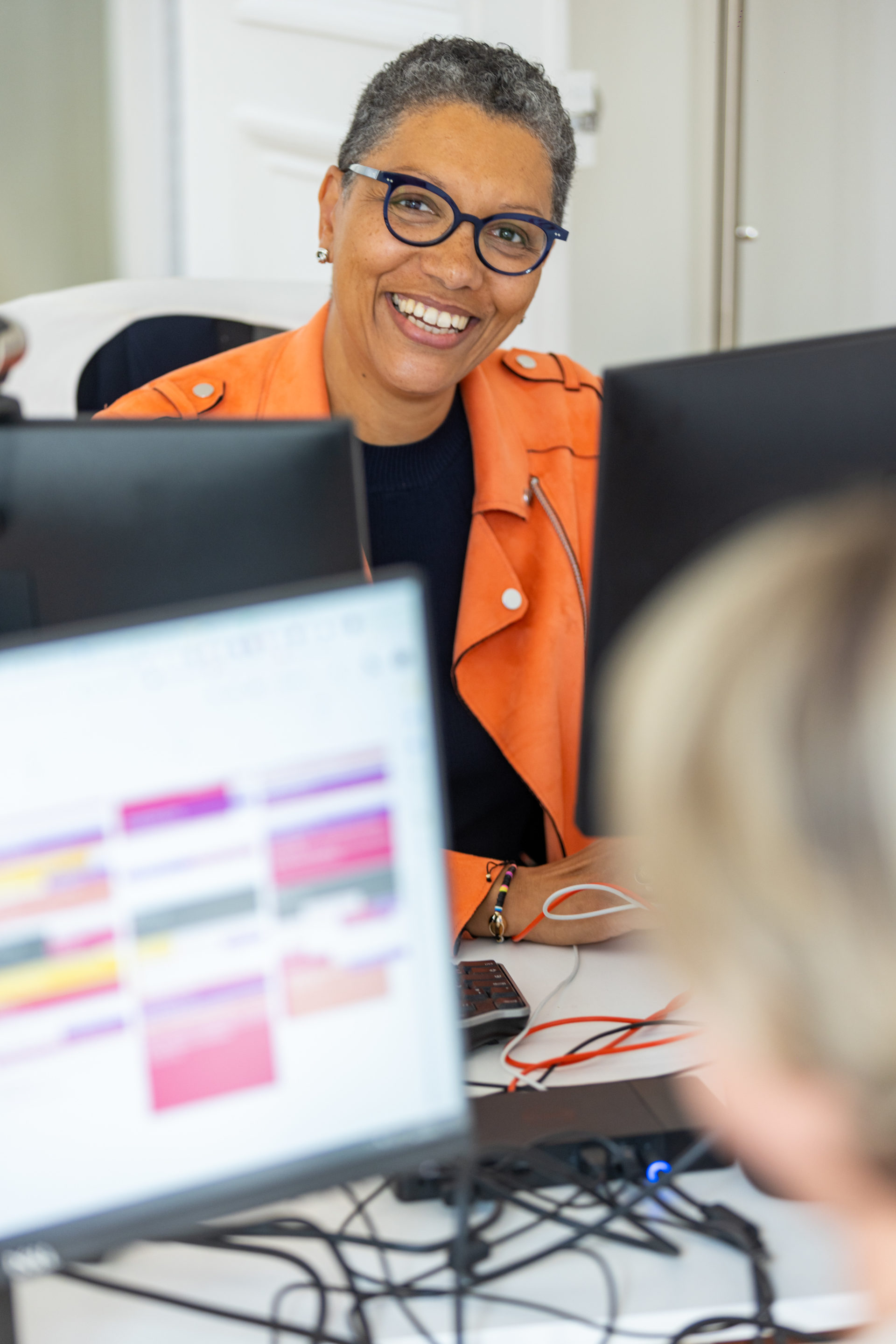 Une collaboratrice souriante assise à son bureau dans l'agence WInbound de Paris